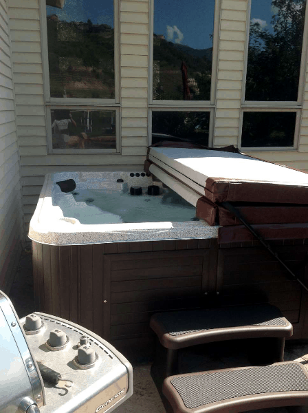Half covered arctic spas hot tub on a patio